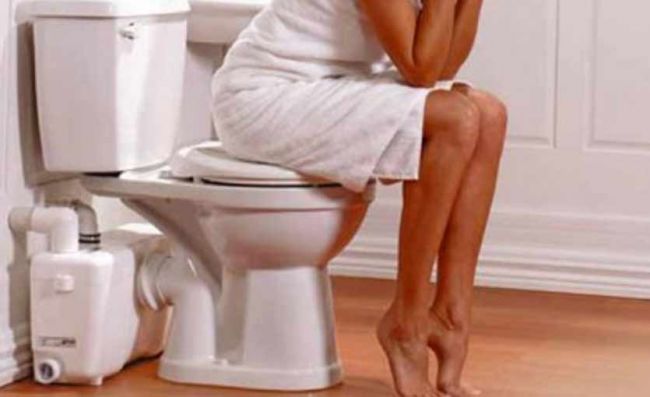 mujer-sentada-inodoro-tapado-estreñimiento