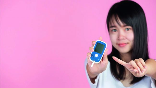 mujer agarrando glucómetro