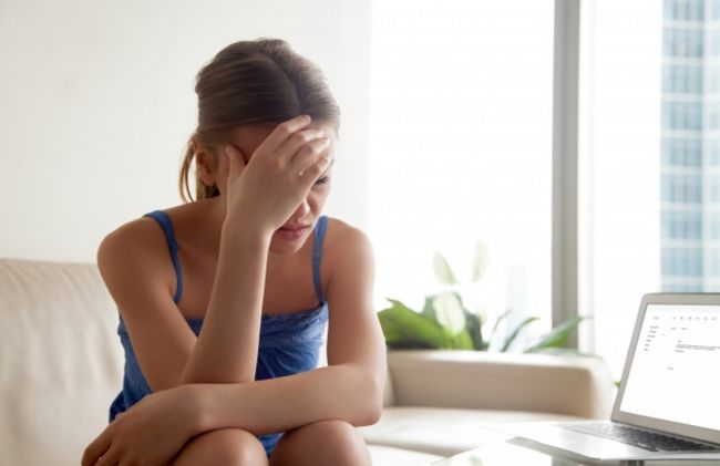 mujer-tocando-cabeza-sentada